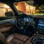 Car dashboard showing software update notification on screen with owner looking at it from driver seat at night